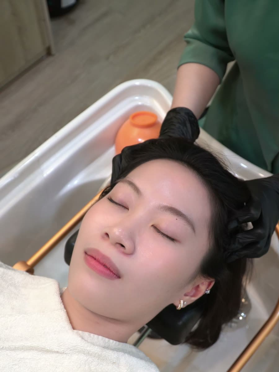 Khách thư giãn dưới đôi tay kỹ thuật viên gội đầu dưỡng sinh